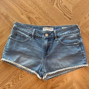 Bullhead low-rise jean shorts with white lace trim